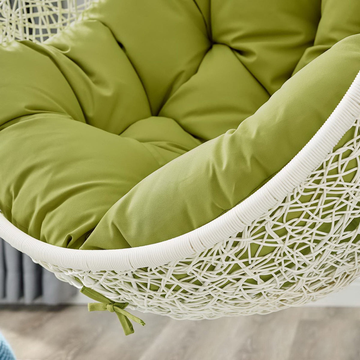 Lime green outdoor hanging chair with thick cushion and white wicker frame on Tampa Home & Garden Store