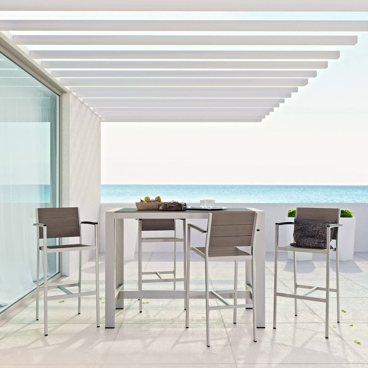 Shore 5-piece outdoor aluminum dining set with tall table and four gray chairs on a sunny patio on Tampa Home & Garden Store