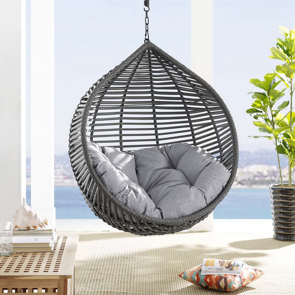 Garner Teardrop Patio Swing Chair with grey cushions in woven hanging wicker daybed on balcony on Tampa Home & Garden Store