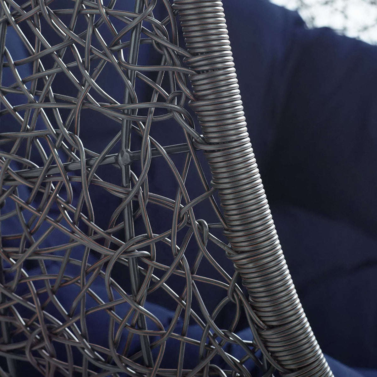 Swing outdoor patio lounge chair frame close-up in dark gray woven metal with coil detailing on Tampa Home & Garden Store