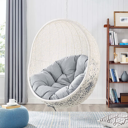 White woven hanging chair with light gray cushions in a cozy living room on Tampa Home & Garden Store