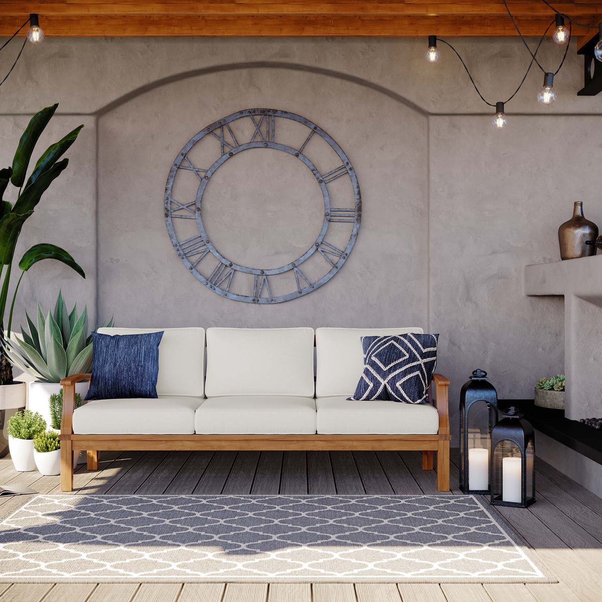 Marina Outdoor Patio Teak Sofa with white cushions and navy pillows in an outdoor lounge on Tampa Home & Garden Store
