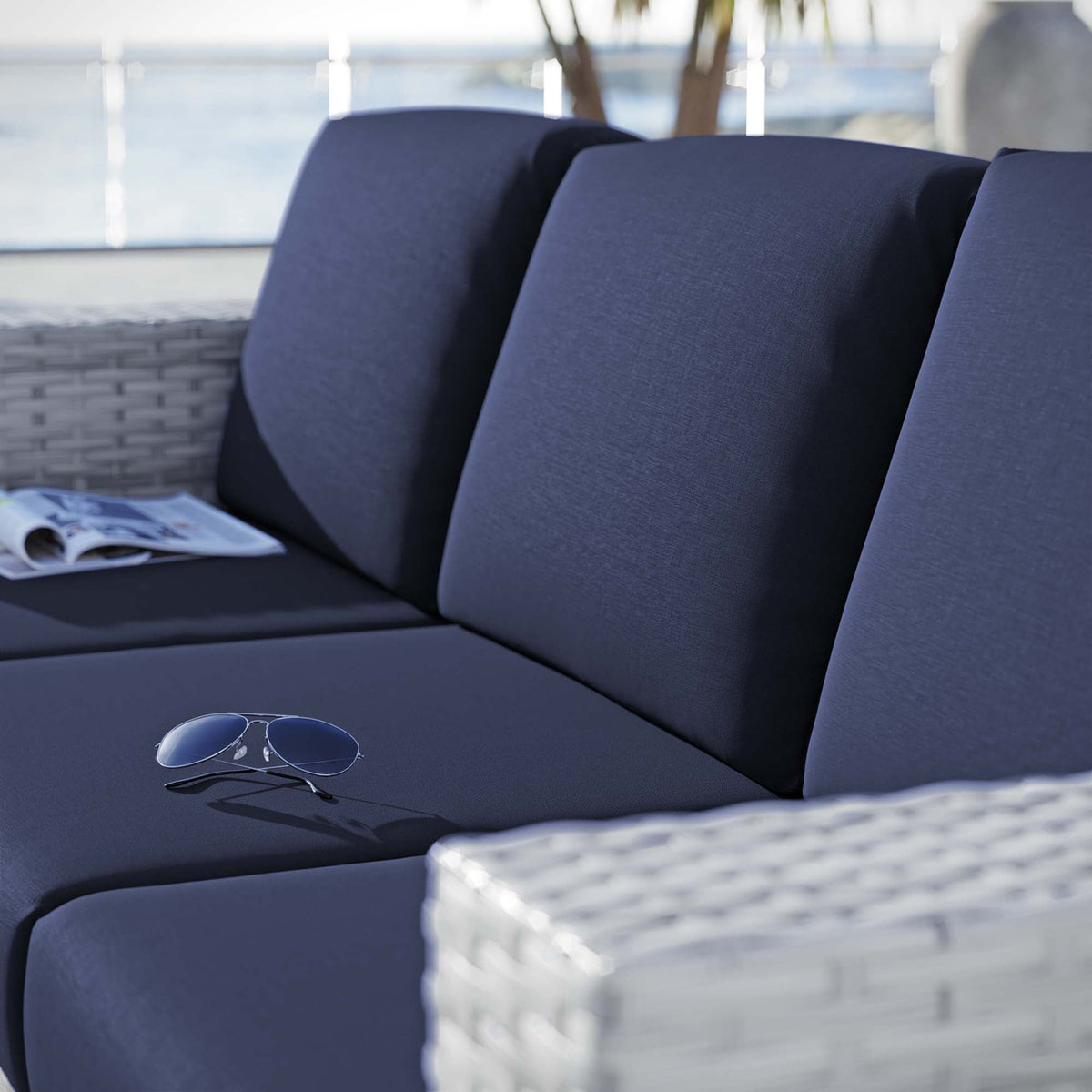 Convene Outdoor Patio Sofa by Modway blue cushions with wicker armrests, sunglasses on seat on Tampa Home & Garden Store