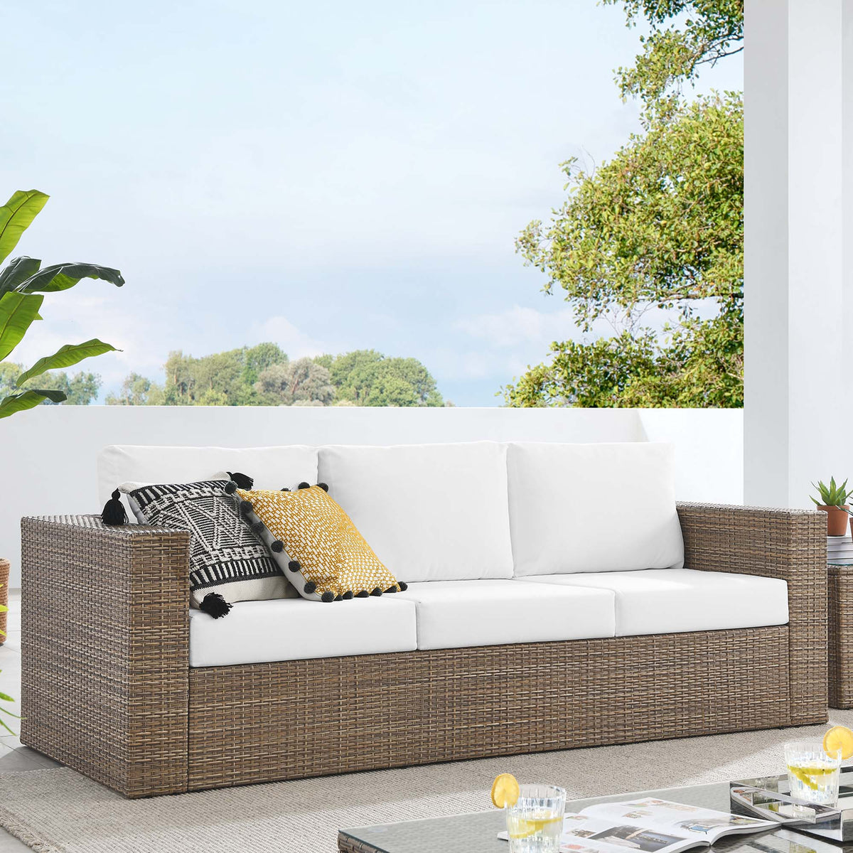 Convene Outdoor Patio Sofa sectional in brown wicker with white cushions and decorative pillows on Tampa Home & Garden Store