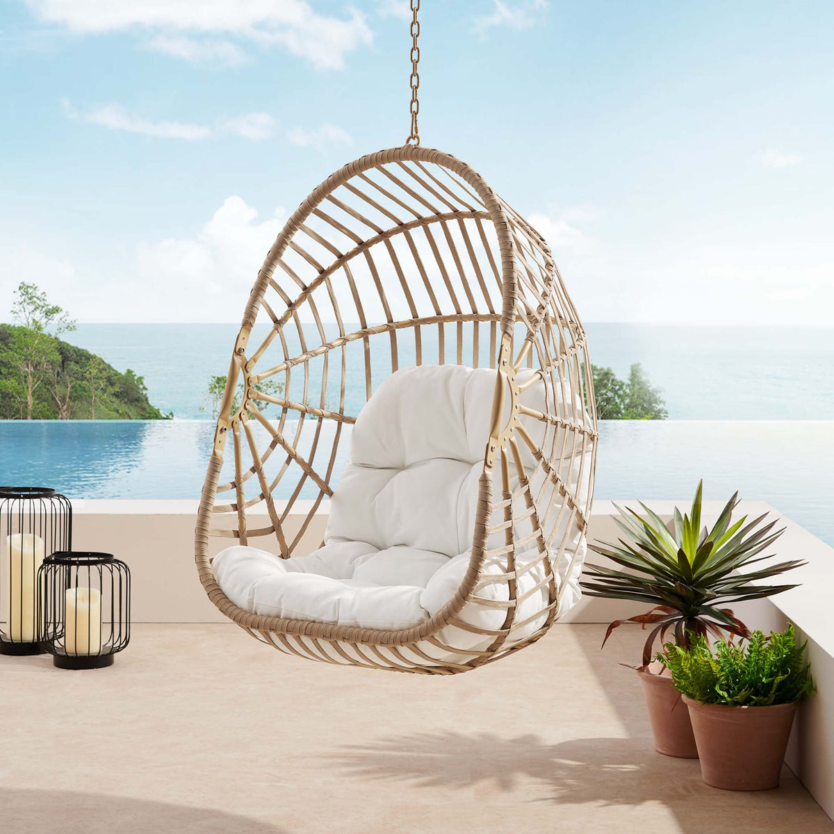 Amalie wicker rattan outdoor swing chair with white cushion, hanging from chain by poolside on Tampa Home & Garden Store
