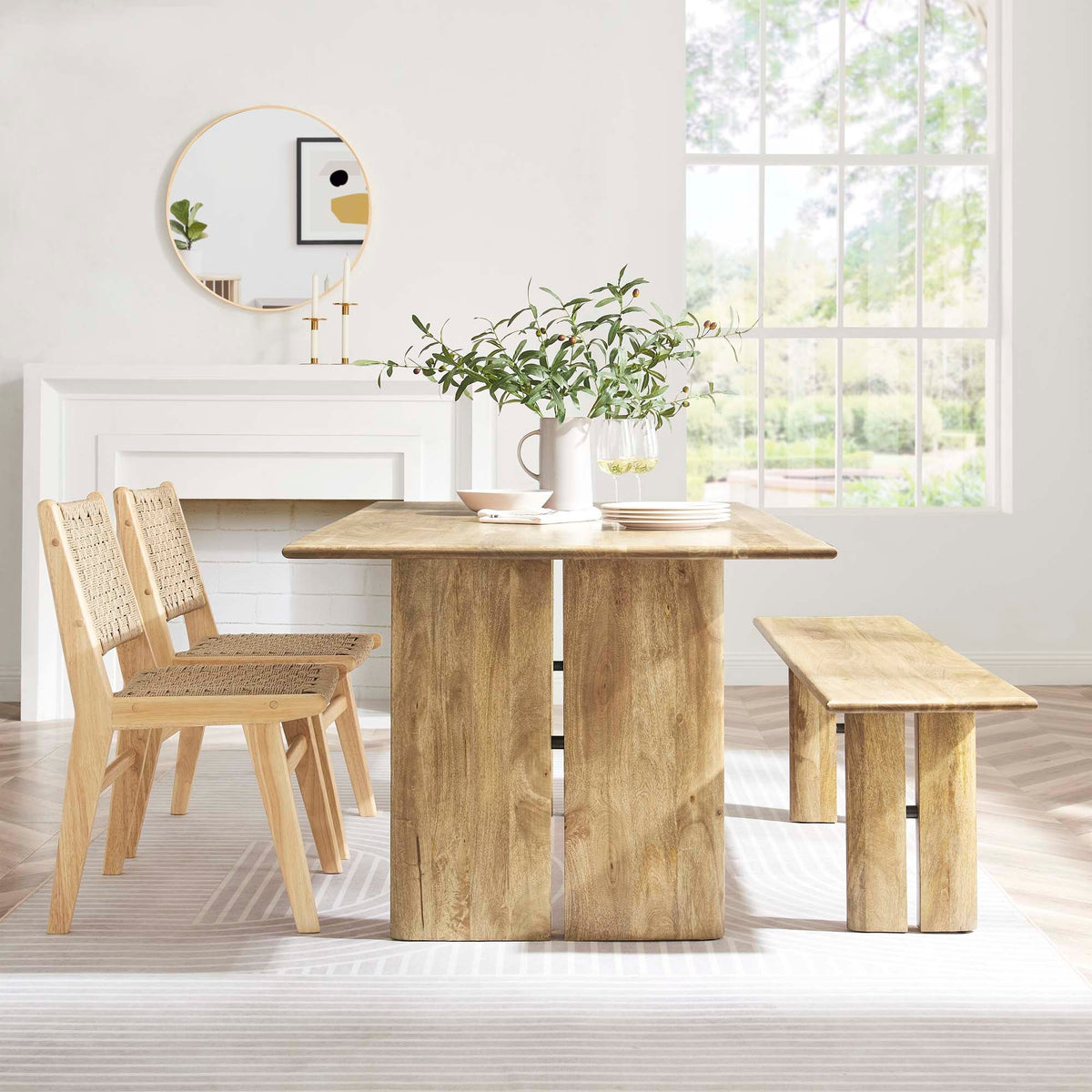 Amistad wood dining table with bench and woven chairs in natural oak finish in dining space on Tampa Home & Garden Store
