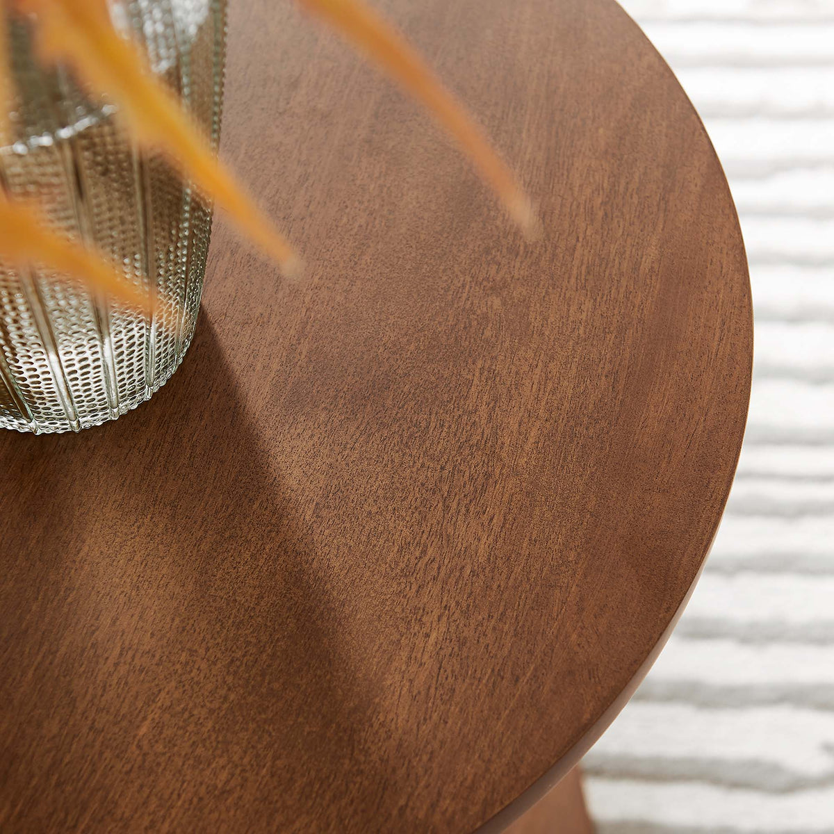 Lina Round Wood Side Table with warm brown finish and visible grain, shown with textured metal vase on Tampa Home & Garden Store