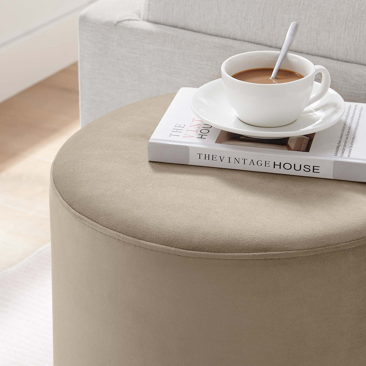 Round beige velvet ottoman Tilden 16in by Modway; seam detail with a coffee cup atop a book on Tampa Home & Garden Store
