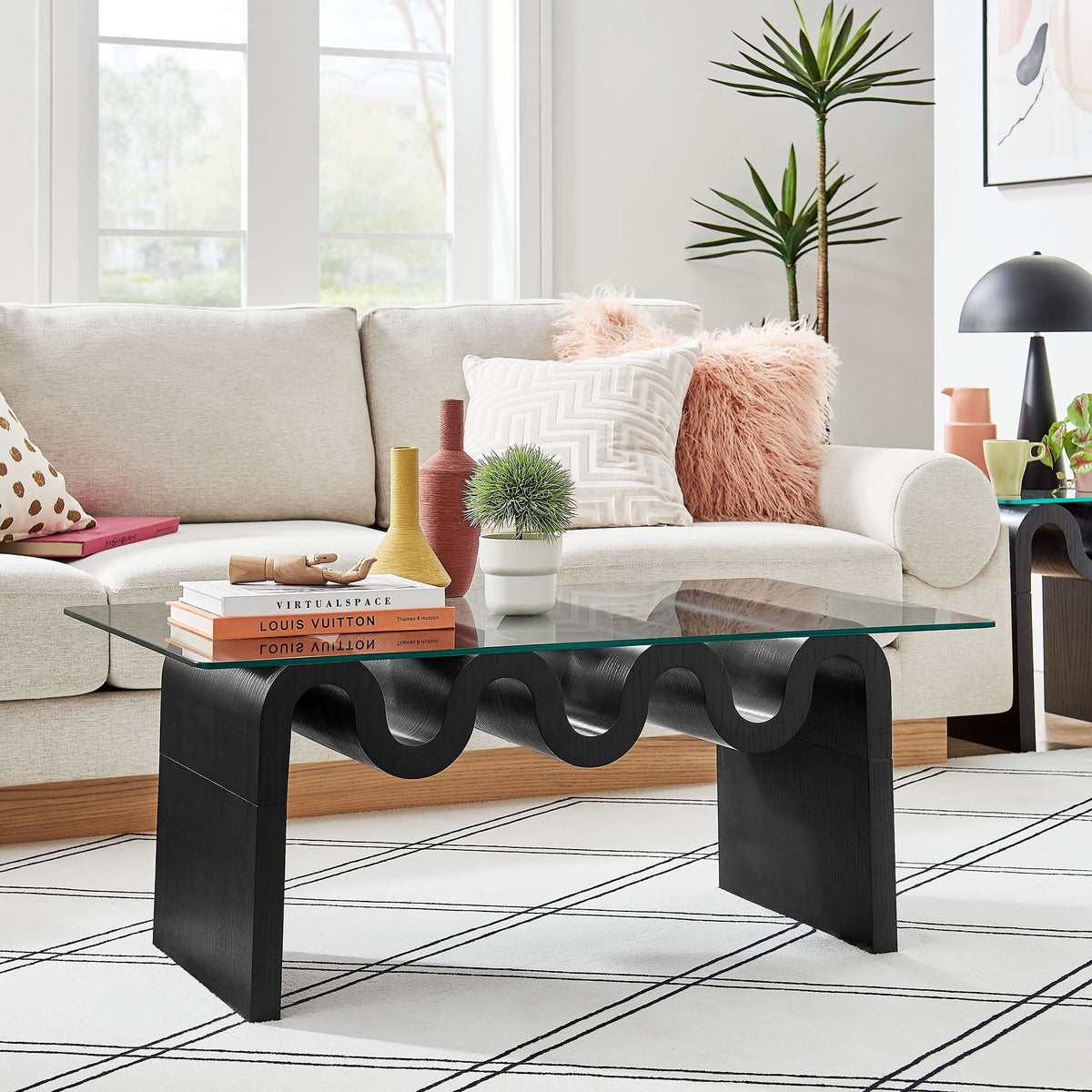 Ondine glass top coffee table with black sculptural loop base in a modern living room on Tampa Home & Garden Store