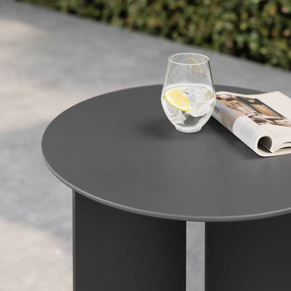 Tecton outdoor patio aluminum round side table in dark gray with a glass of water and lemon on Tampa Home & Garden Store