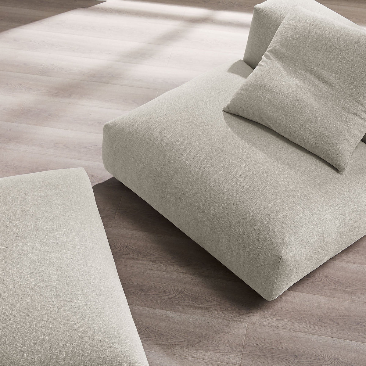 Solace modular armless chair and ottoman in beige fabric with plush cushions on wood floor on Tampa Home & Garden Store