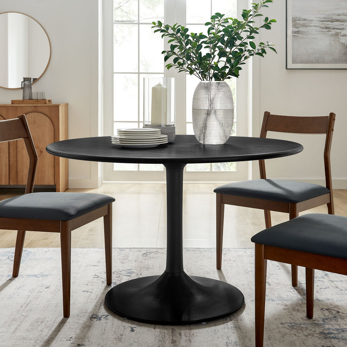 Lippa 48in Round Dining Table with black top, pedestal base, plates and plant on Tampa Home & Garden Store