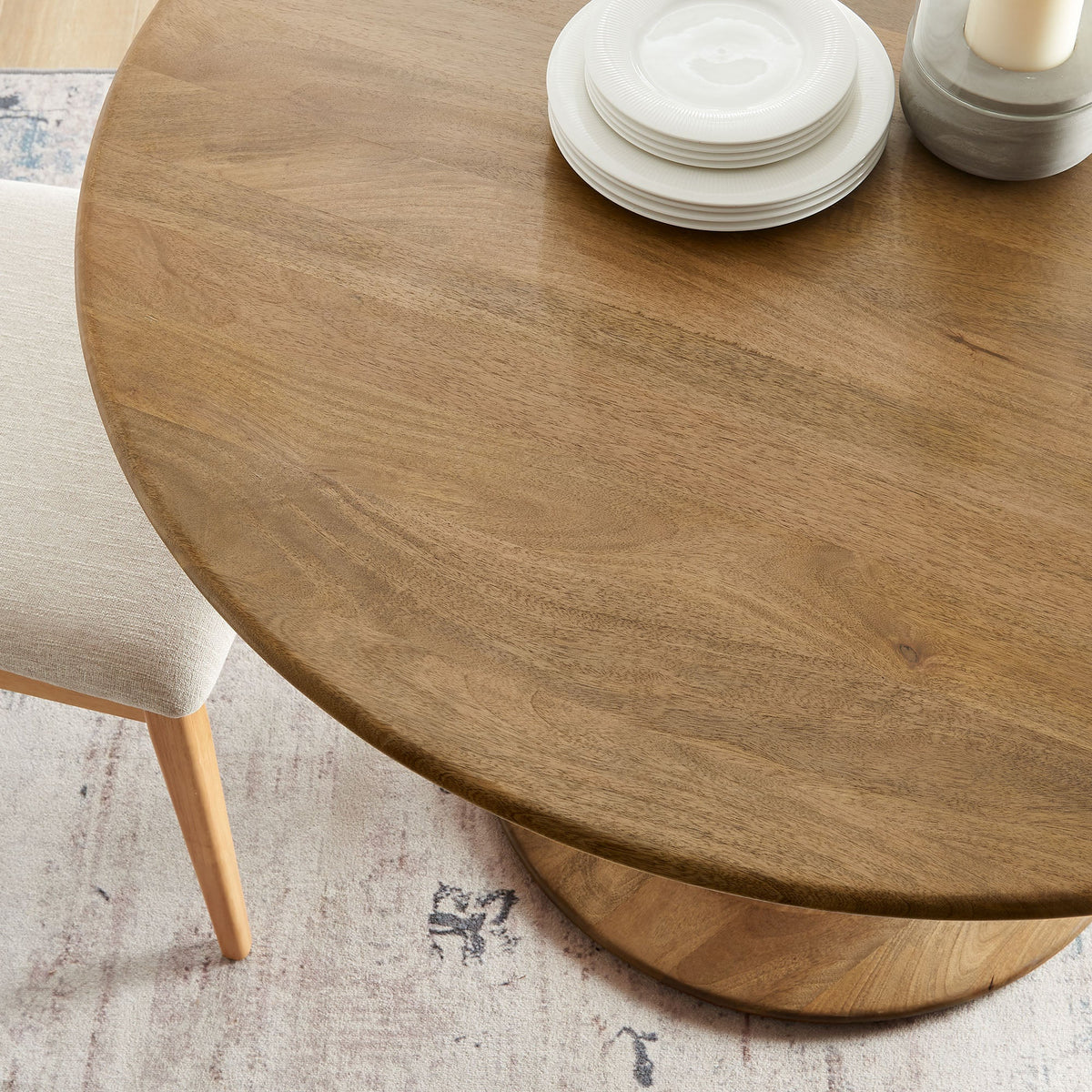 Lippa 48in round solid wood dining table with white plate stack and candle centerpiece on Tampa Home & Garden Store