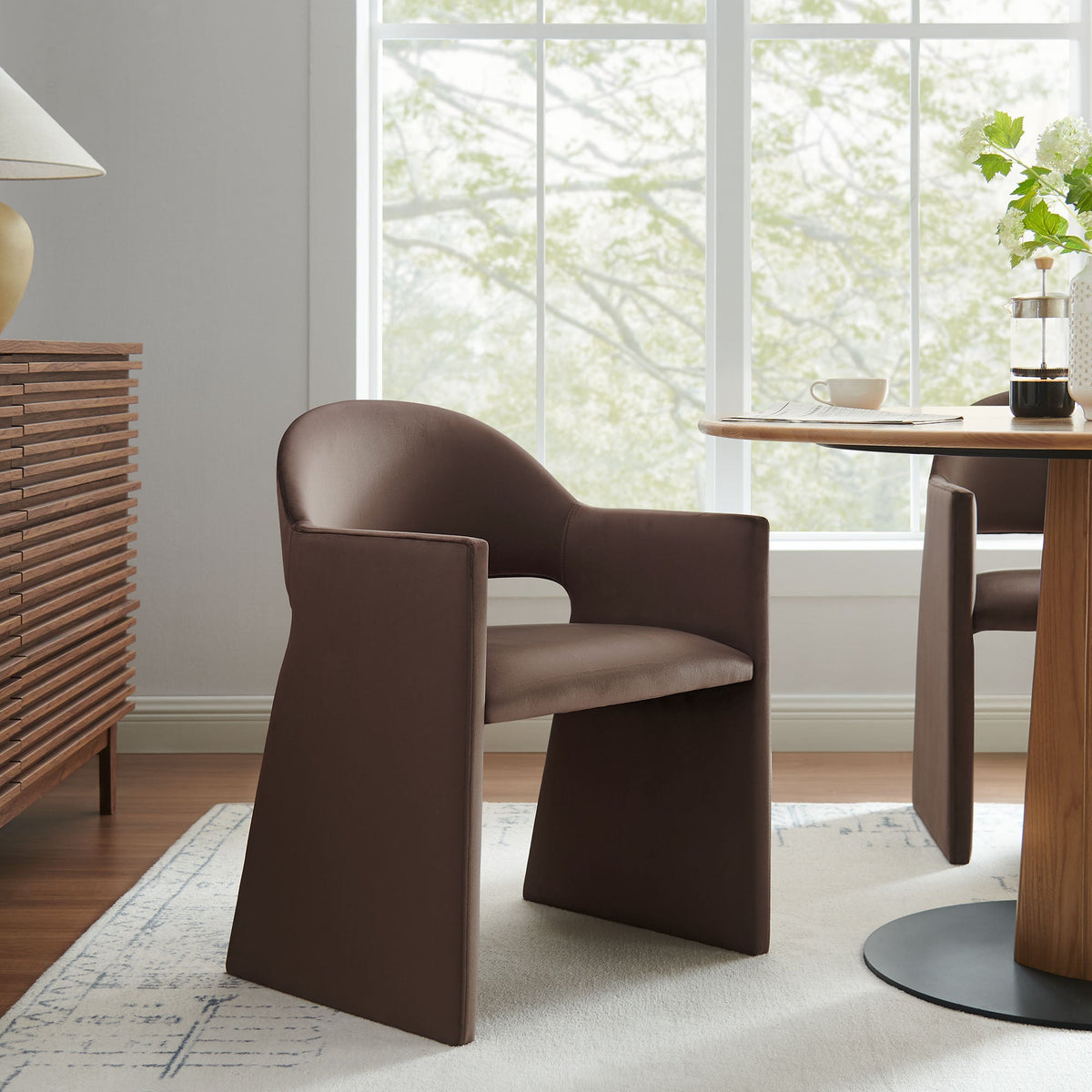 Two Talia Performance Velvet Dining Armchairs in brown around a round wooden table by a bright window on Tampa Home & Garden Store