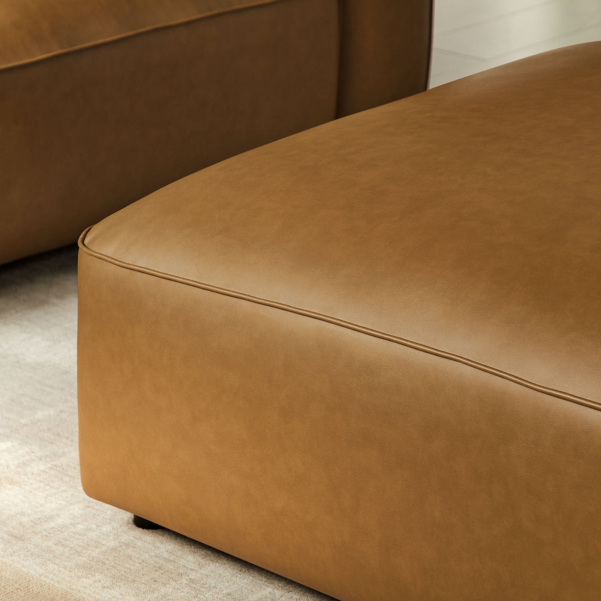Auren upholstered vegan leather ottoman in tan brown with visible seam on Tampa Home & Garden Store