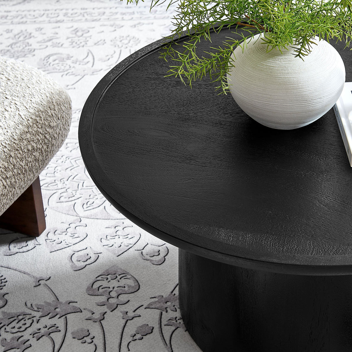 Holloway 30in round mango wood coffee table topped with a gray textured vase and greenery on Tampa Home & Garden Store