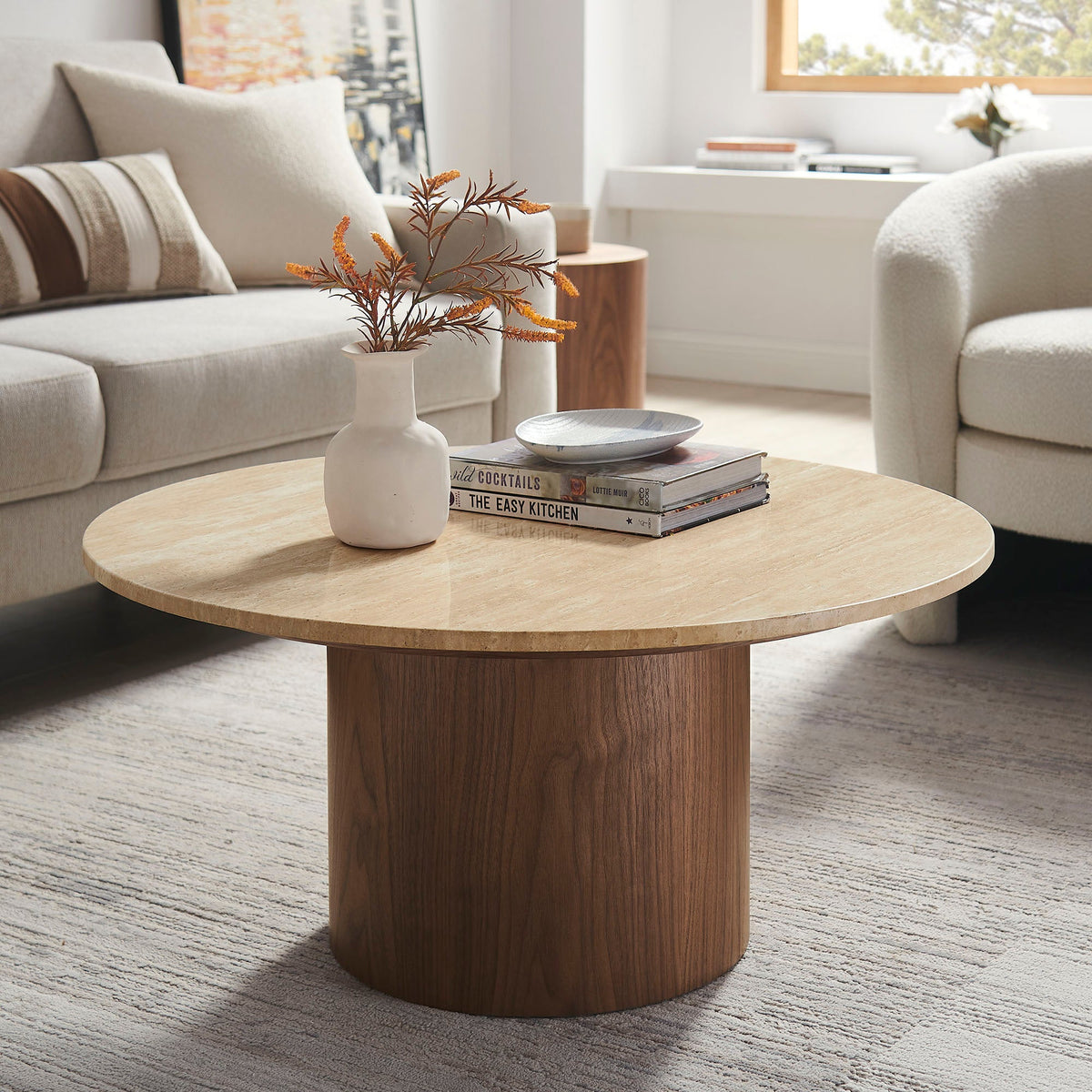 Kioni Round Travertine Coffee Table with wood base in a bright living room on Tampa Home & Garden Store