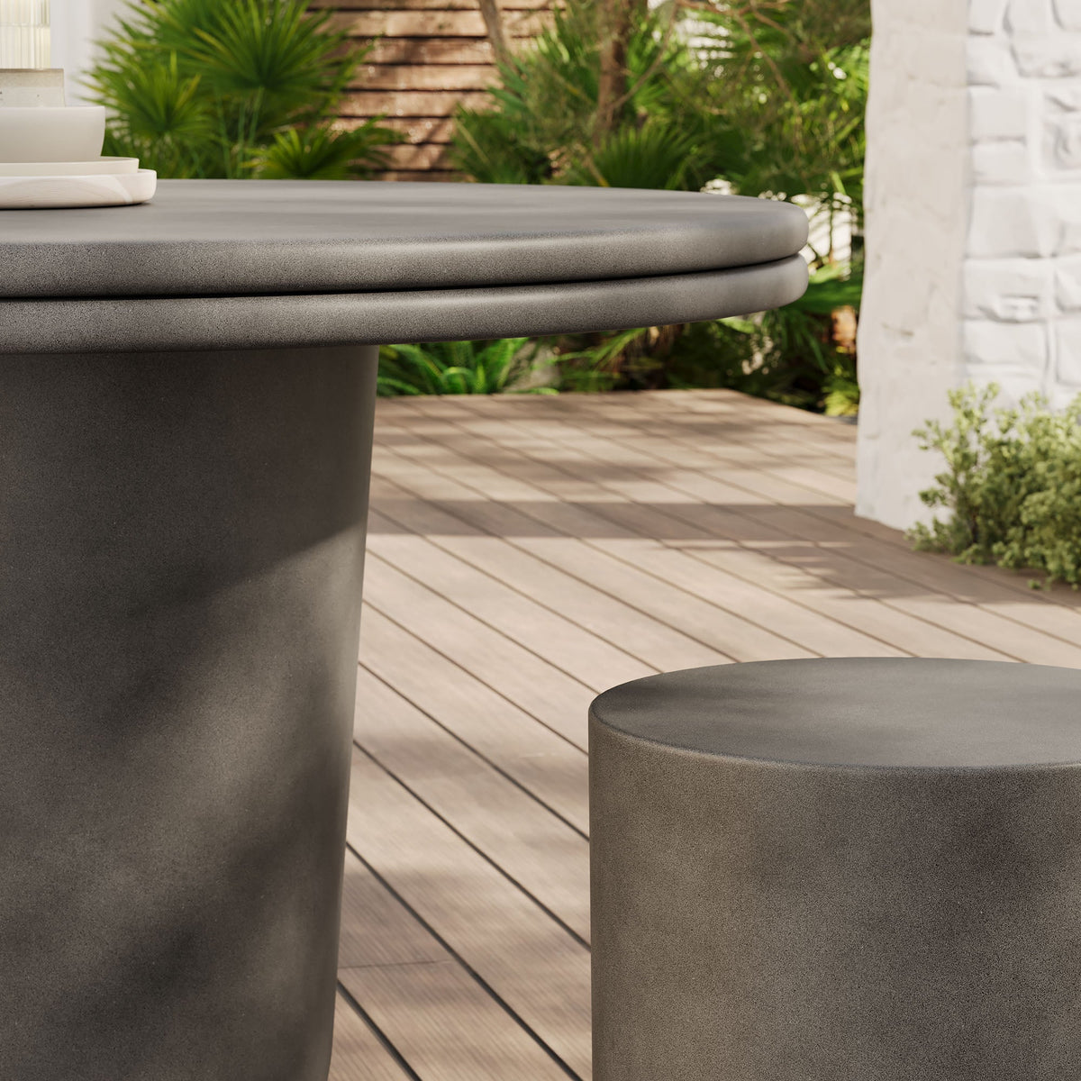 Brion concrete outdoor dining table with rounded edge and matching stools on a wooden deck on Tampa Home & Garden Store