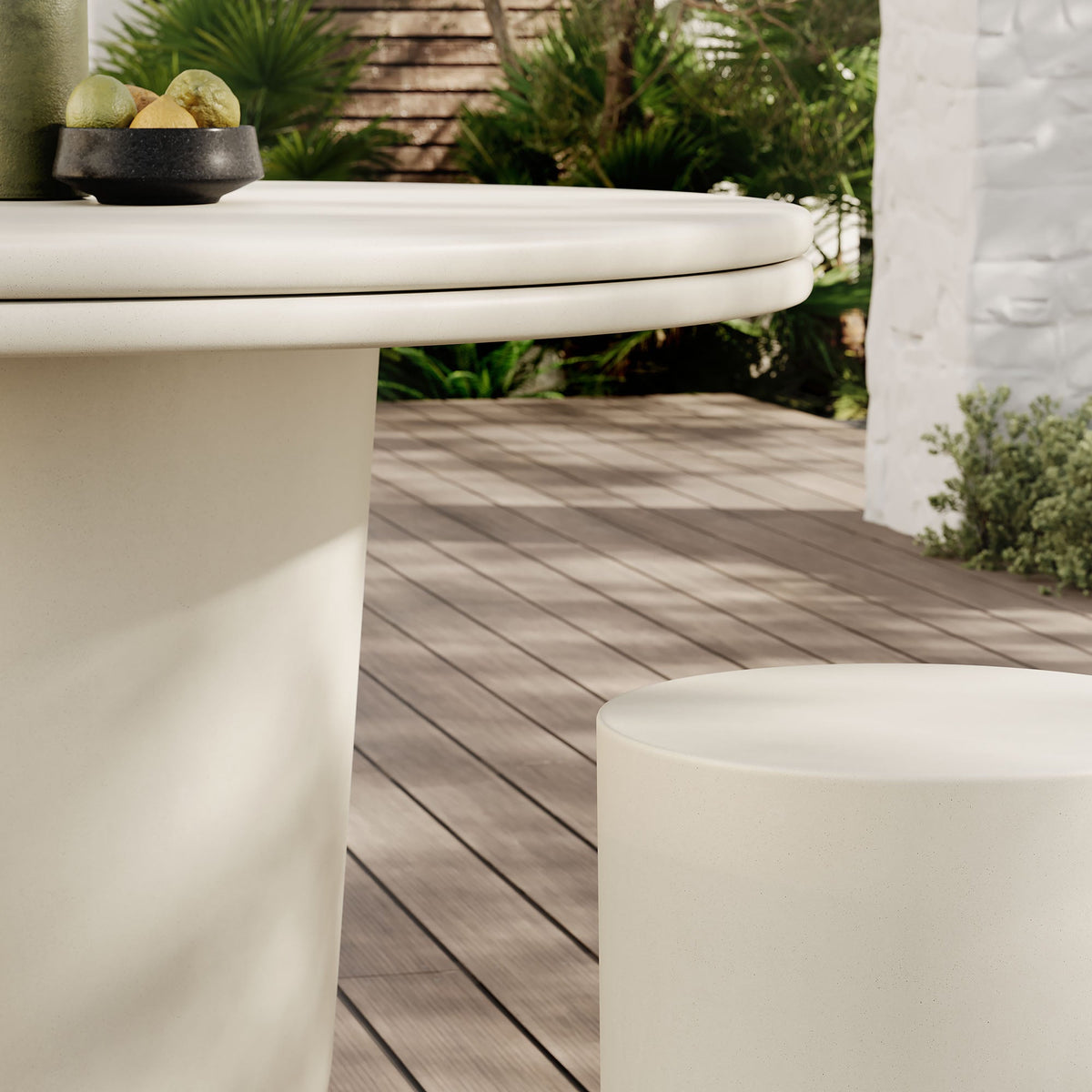 Brion concrete dining table round top with pedestal base; fruit bowl on surface in garden setting on Tampa Home & Garden Store