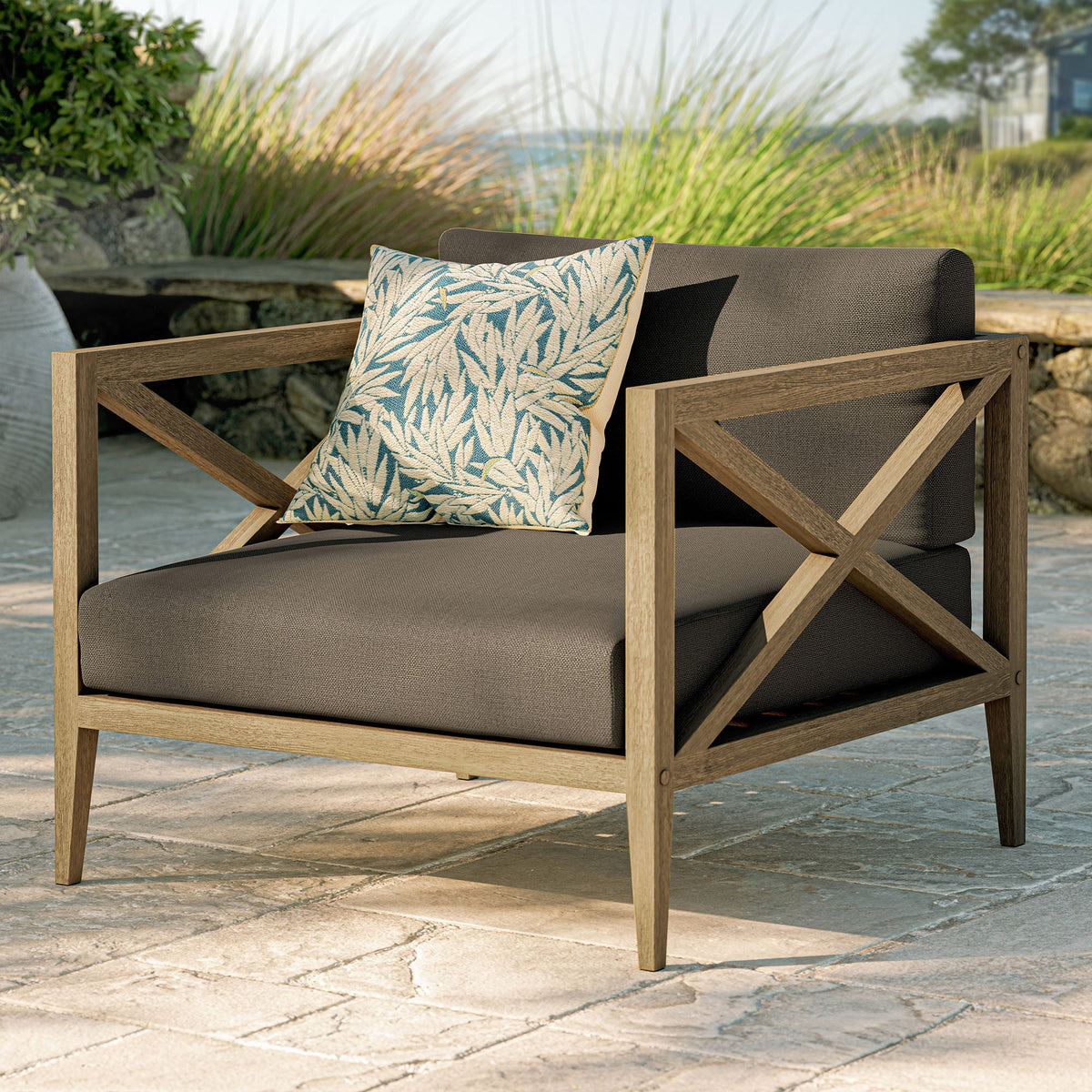 Northlake outdoor teak armchair with dark brown cushions and blue leaf-pattern pillow on Tampa Home & Garden Store