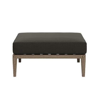 Northlake outdoor teak ottoman with dark woven cushion and exposed teak legs on Tampa Home & Garden Store