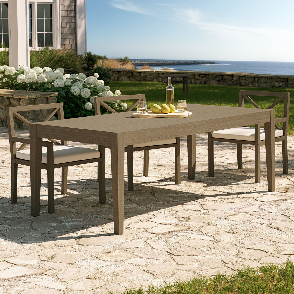 Northlake 83in teak outdoor dining table with four X-back chairs on seaside patio on Tampa Home & Garden Store