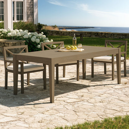 Northlake 83in teak outdoor dining table with four X-back chairs on seaside patio on Tampa Home & Garden Store