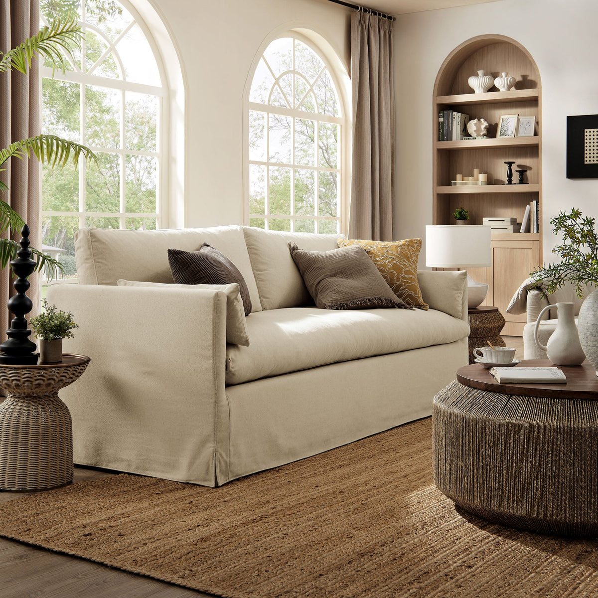 Wellfleet 85-inch slipcovered beige fabric sofa in a sunlit living room with arched windows on Tampa Home & Garden Store