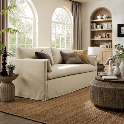 Wellfleet 85-inch slipcovered beige fabric sofa in a sunlit living room with arched windows on Tampa Home & Garden Store
