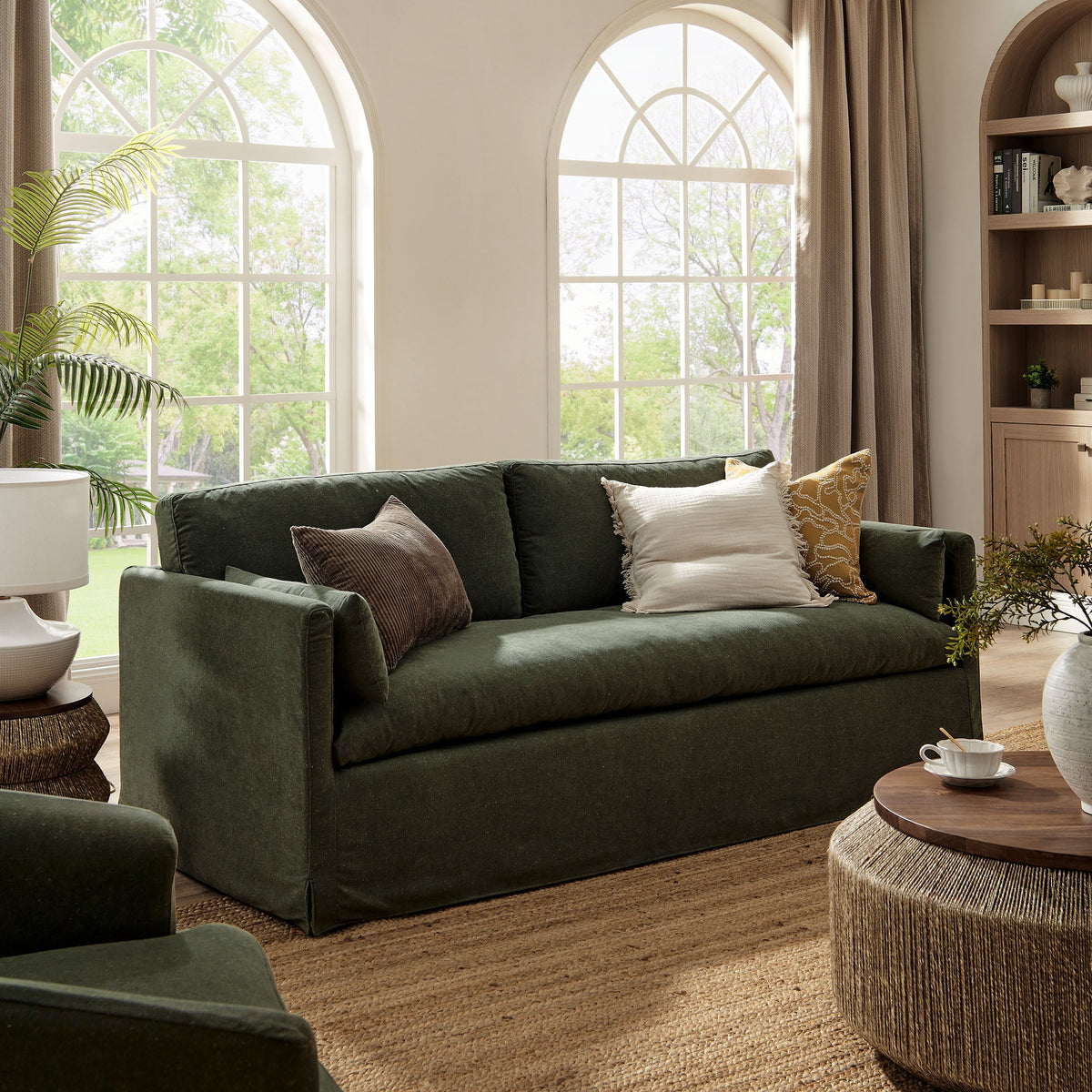 Wellfleet 85-inch slipcovered fabric sofa in forest green with neutral cushions in living space on Tampa Home & Garden Store