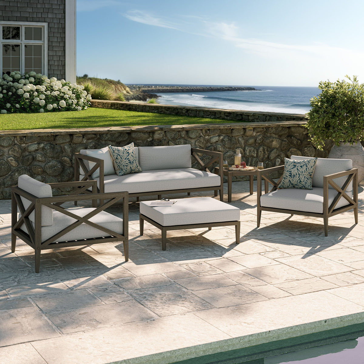 Northlake 5-piece outdoor teak furniture set with light cushions on a coastal stone patio on Tampa Home & Garden Store