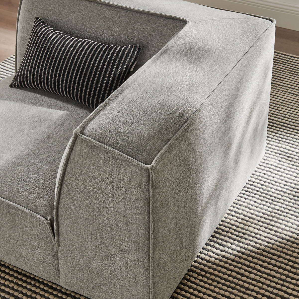 Restore Performance Fabric Upholstered Modular Corner Chair in gray with striped pillow on Tampa Home & Garden Store