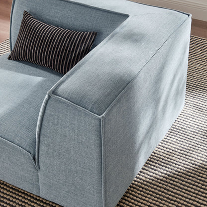 Modular corner chair in blue performance fabric with a black striped bolster pillow on Tampa Home & Garden Store