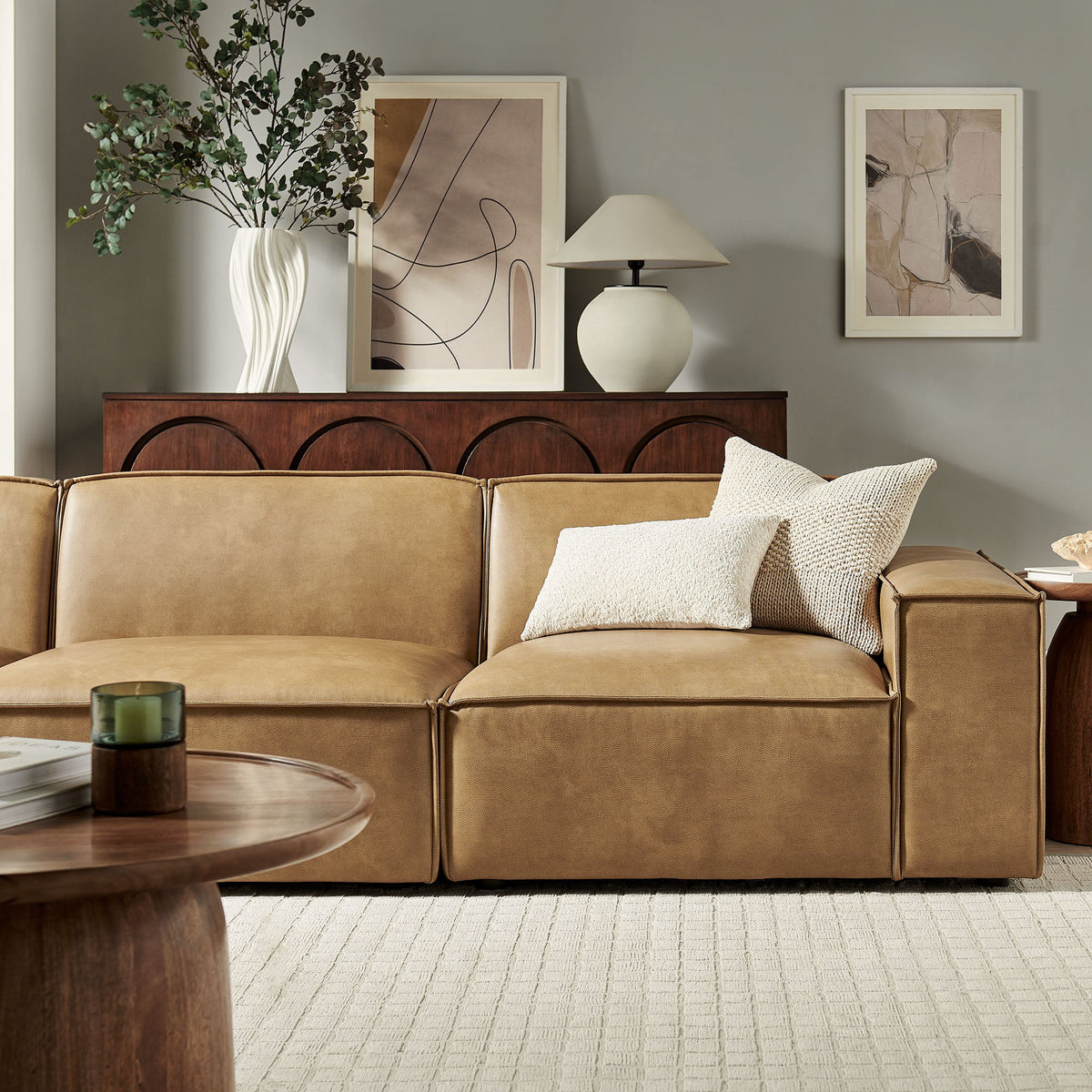 Restore 3-Piece vegan leather modular sofa set in warm tan with a wood console and abstract art on Tampa Home & Garden Store