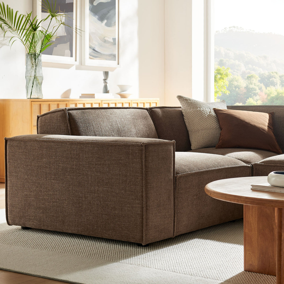Modular L-shaped sectional sofa in mocha performance fabric with plush cushions in a sunlit living room on Tampa Home & Garden Store