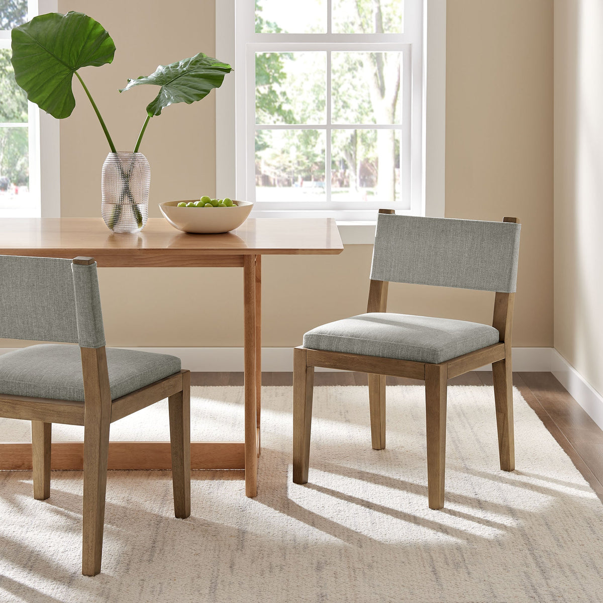Calder fabric upholstered wood armless dining chair in light gray fabric with natural wood legs on Tampa Home & Garden Store