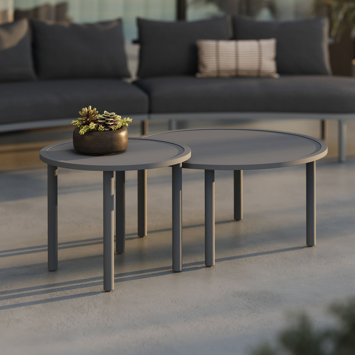 Porta 2-Piece Nesting Outdoor Aluminum Coffee Tables in gray with a bronze planter on one table on Tampa Home & Garden Store