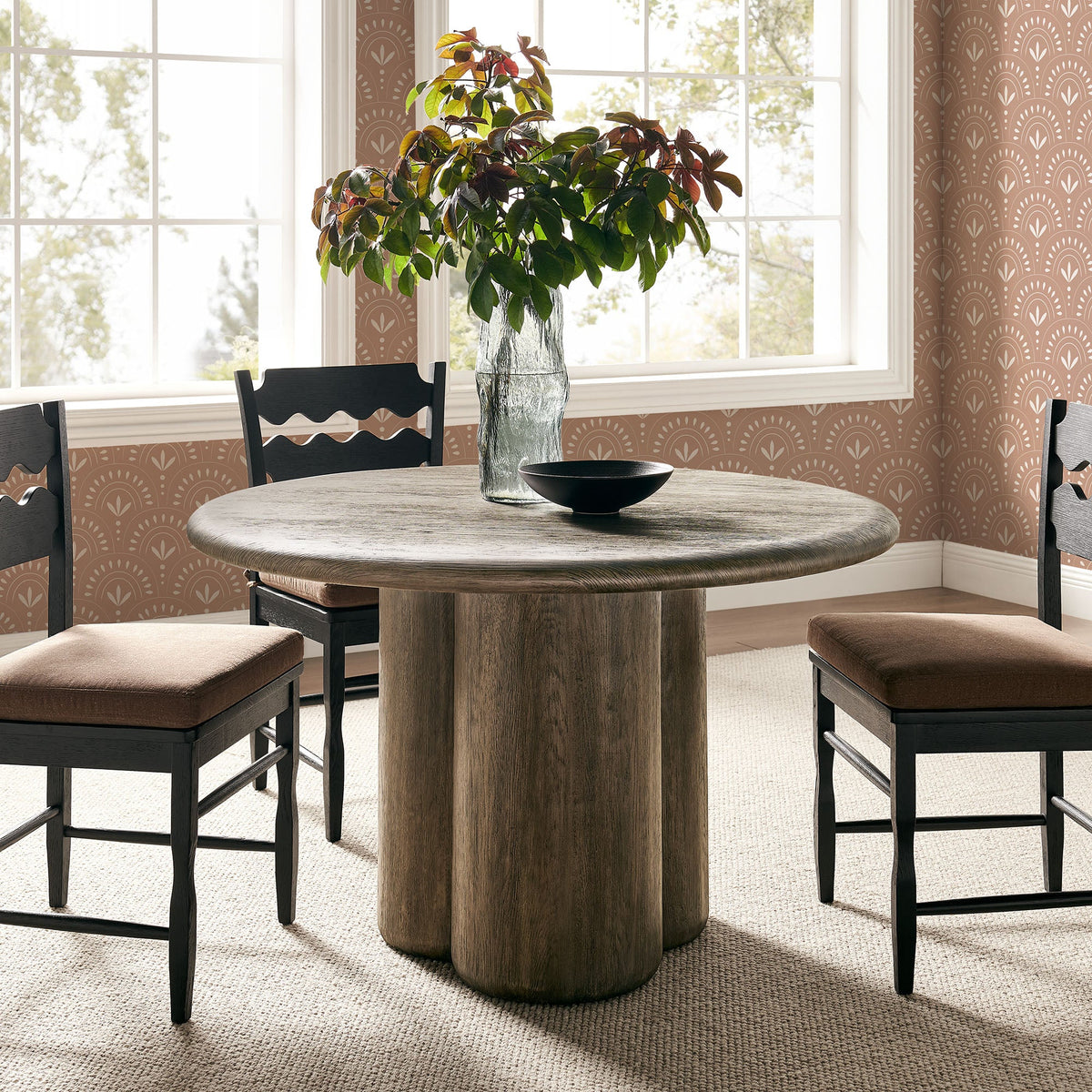 Tori 48-inch round dining table with wood top and dark base, black chairs in bright dining room on Tampa Home & Garden Store