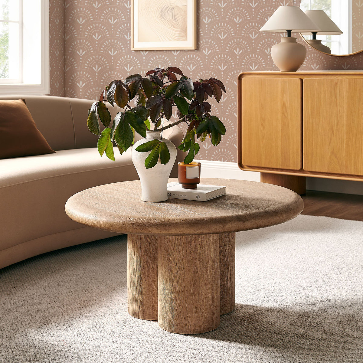 Tori 31-inch round patio coffee table in natural wood with plant vase and candle in living room on Tampa Home & Garden Store