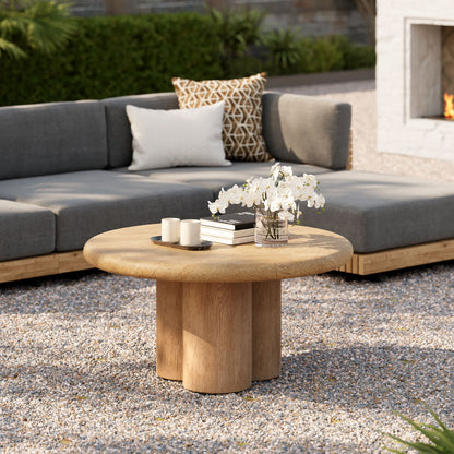 Tori 31in round indoor outdoor patio coffee table beige stone top with natural wood pedestal on grey sectional on Tampa Home & Garden Store