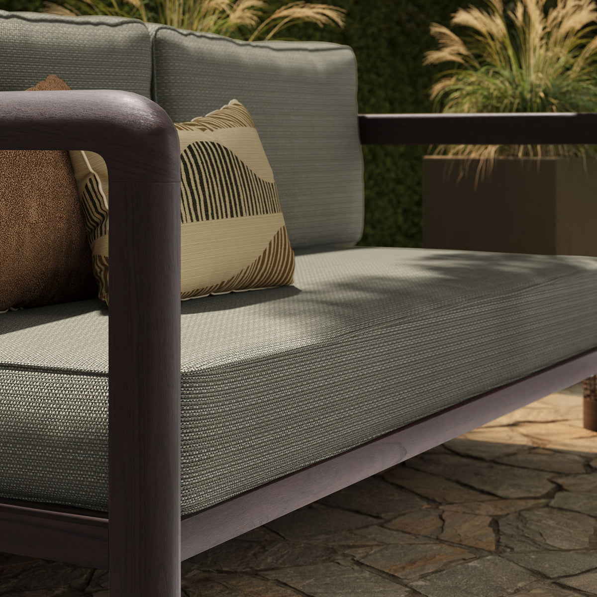 Kona outdoor teak wood loveseat with dark brown frame and gray woven cushions, striped pillow on Tampa Home & Garden Store
