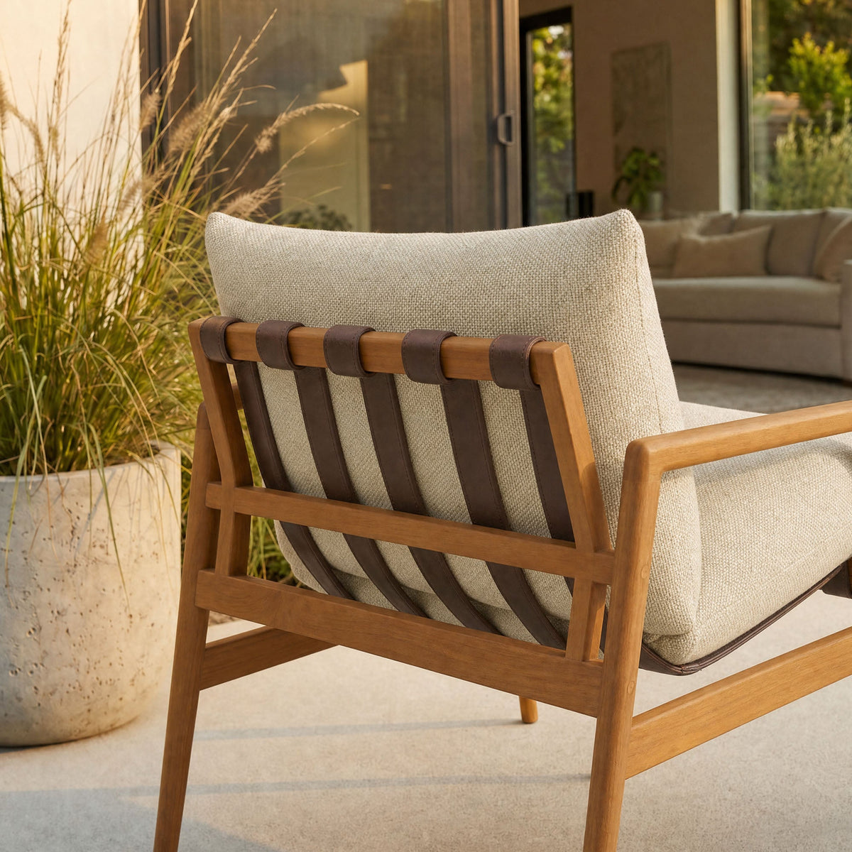 Nomi outdoor teak wood sling chair with beige cushion and leather straps on teak frame on Tampa Home & Garden Store