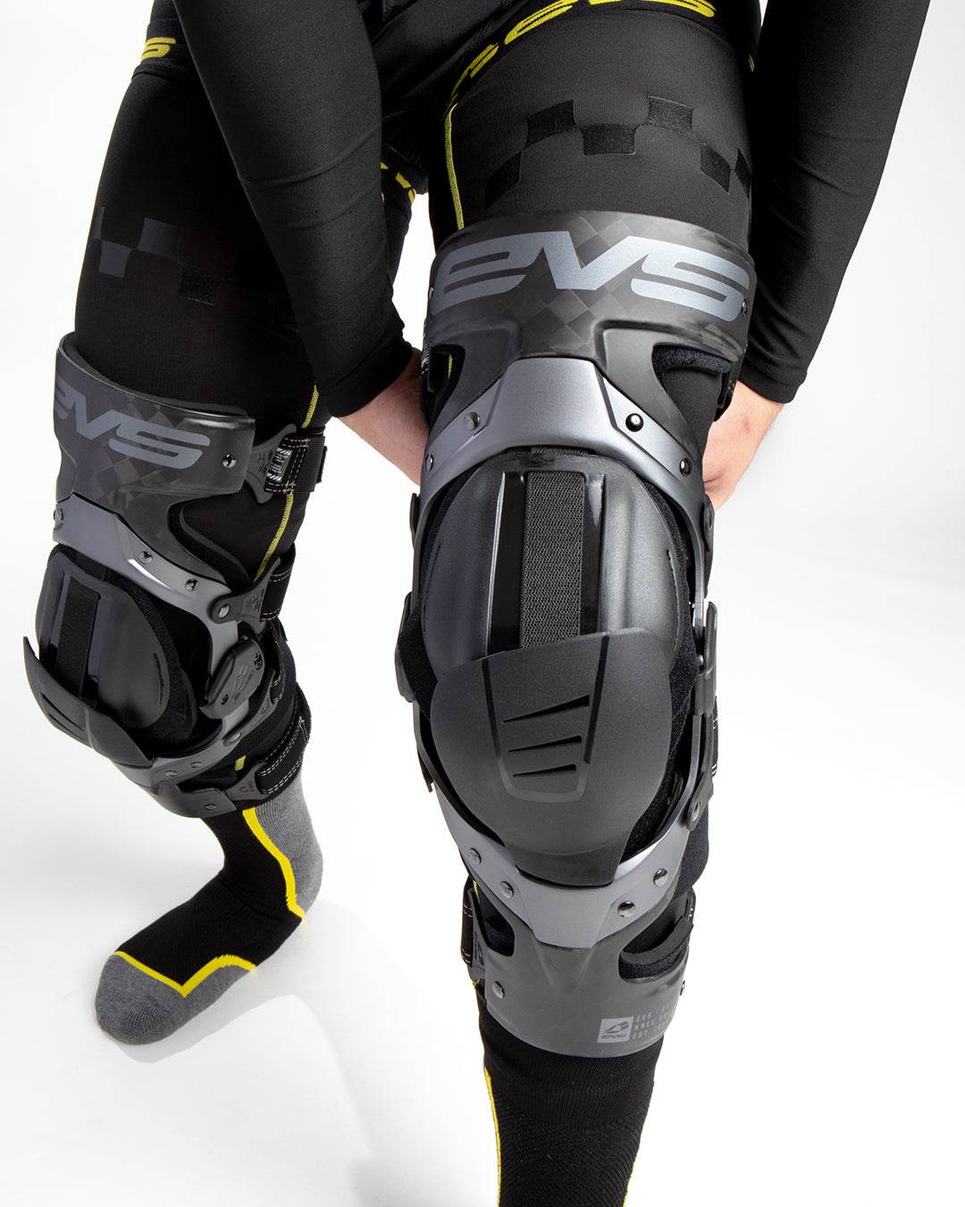 Axis Pro 2025 Knee Brace by EVS Sports; gray/black hard-shell knee guards with multiple straps on Tampa Home & Garden Store
