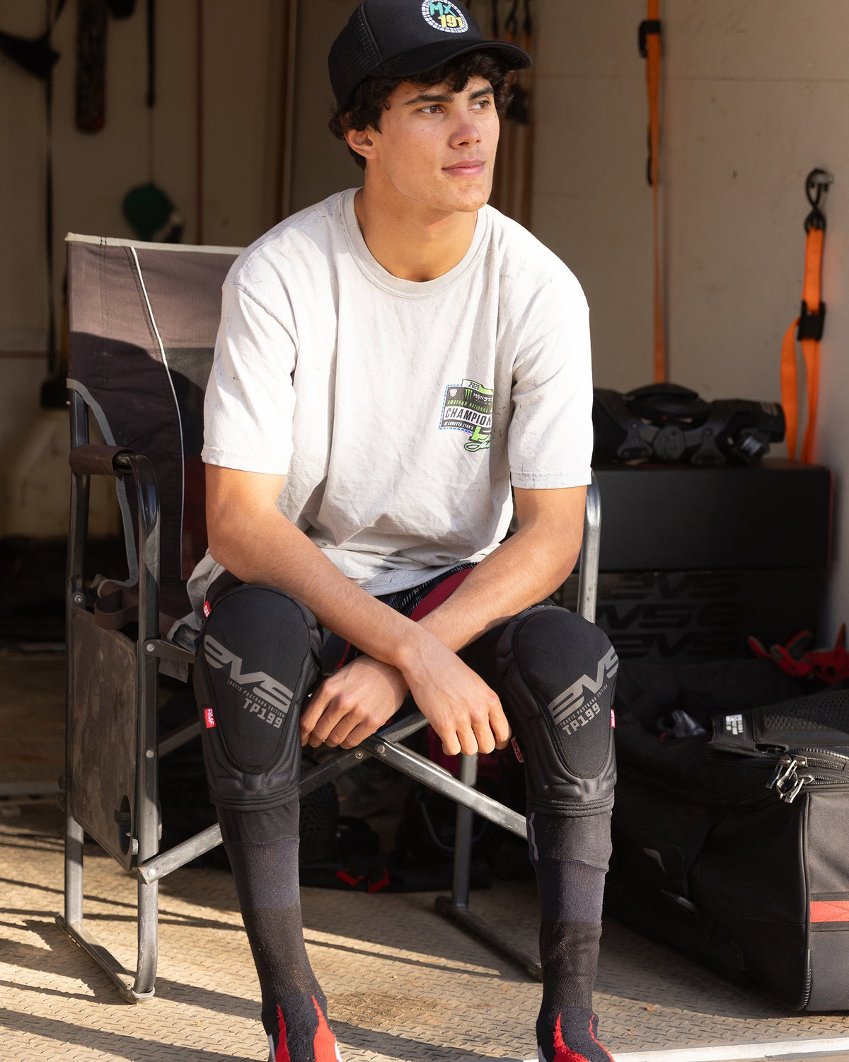 TP199 Lite Blackout Knee Guard by EVS Sports; black knee pads on a seated man on Tampa Home & Garden Store