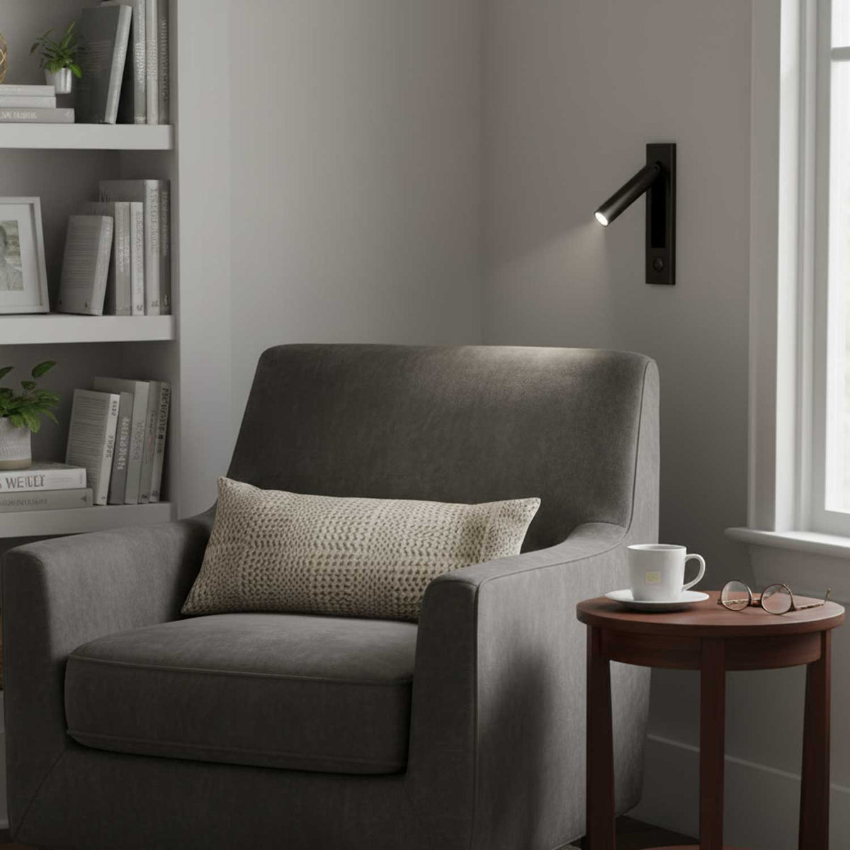 Moktan Sabai black folding bedside wall sconce with warm LED reading light beside gray chair on Tampa Home & Garden Store