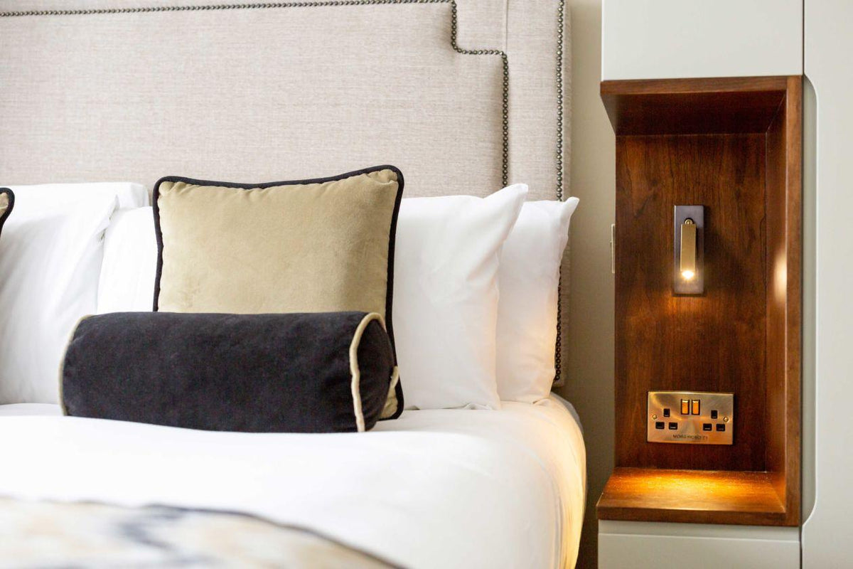 Recessed Folding Bedside Wall Sconce by Moktan Sabai with warm LED on a wooden bedside panel on Tampa Home & Garden Store