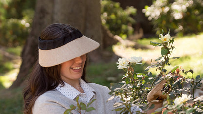 EquiVisor Original Shorty 3 sun visor in beige with black band worn by woman near roses on Tampa Home & Garden Store