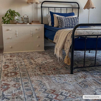 Erez Flat Pile Washable Rug Boutique Rugs in blue beige tones under a black metal bed on Tampa Home & Garden Store