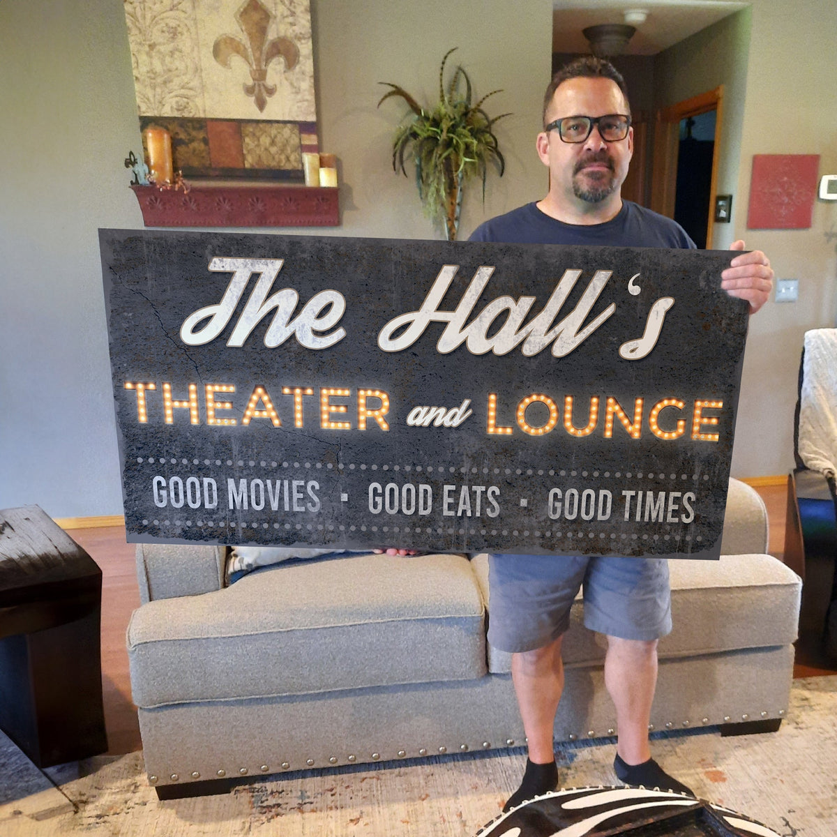 Family Theater and Lounge Sign III canvas with lit marquee letters held by a man on Tampa Home & Garden Store