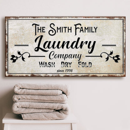 Canvas sign reading Smith Family Laundry Company Wash Dry Fold with rustic frame on Tampa Home & Garden Store